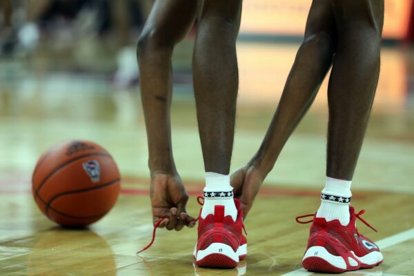 Duke Advances in the ACC Tournament a close up of a basketball player tying his shoes